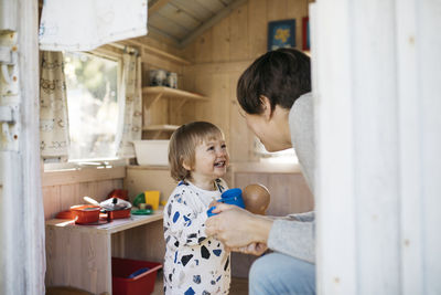 Toddler girl with mother in playhouse
