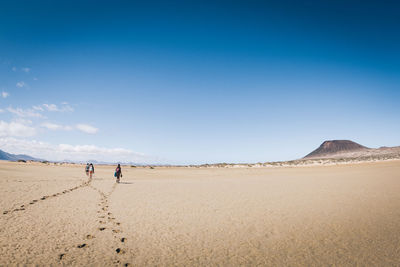 Scenic view of desert against clear blue sky