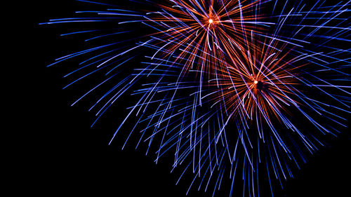 Low angle view of firework display at night