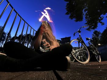 Low angle view of man sitting on bicycle against sky