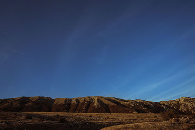 Scenic view of mountains against blue sky