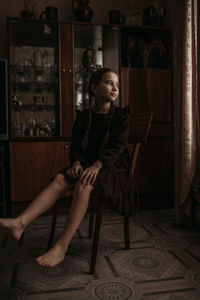 Portrait of young woman playing guitar at home