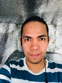 Close-up portrait of young man against wall