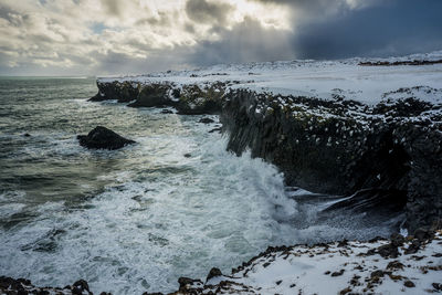 Rocks in sea against sky