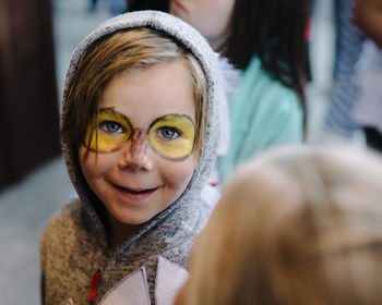 Portrait of cute smiling boy with face paint wearing costume during halloween