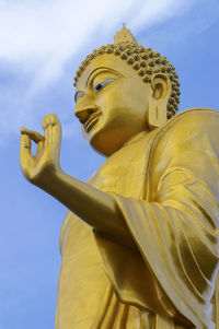 Low angle view of statue against temple against sky