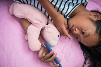 High angle view of baby girl lying on bed at home