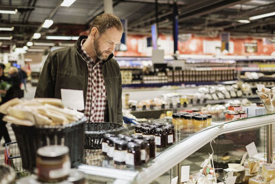 Thoughtful male customer shopping at supermarket