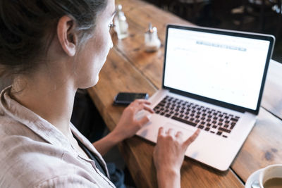 Young woman working with laptop in a coffee shop