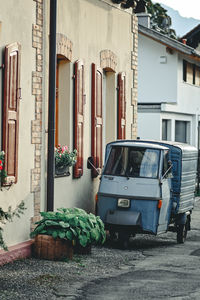 Cars on street by house in city