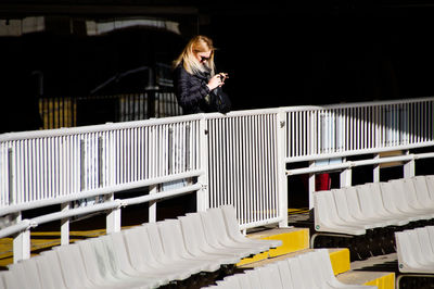Woman using mobile phone in stadium