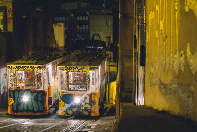 Illuminated street amidst buildings in city at night