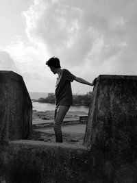 Side view of man standing against wall