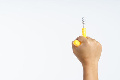 Close-up of hand holding ice cream over white background