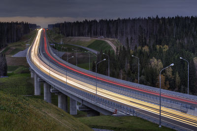 Light trails on road against sky at night