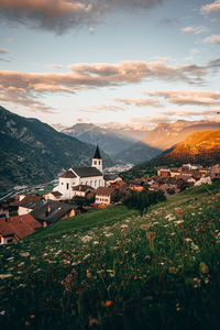 Scenic view of residential buildings by mountains against sky