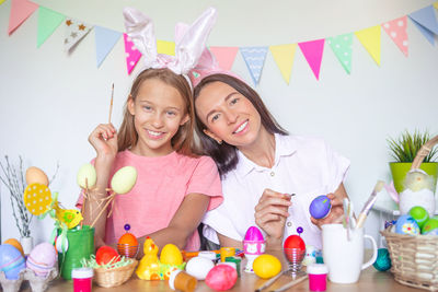 Portrait of smiling girl and woman standing on table