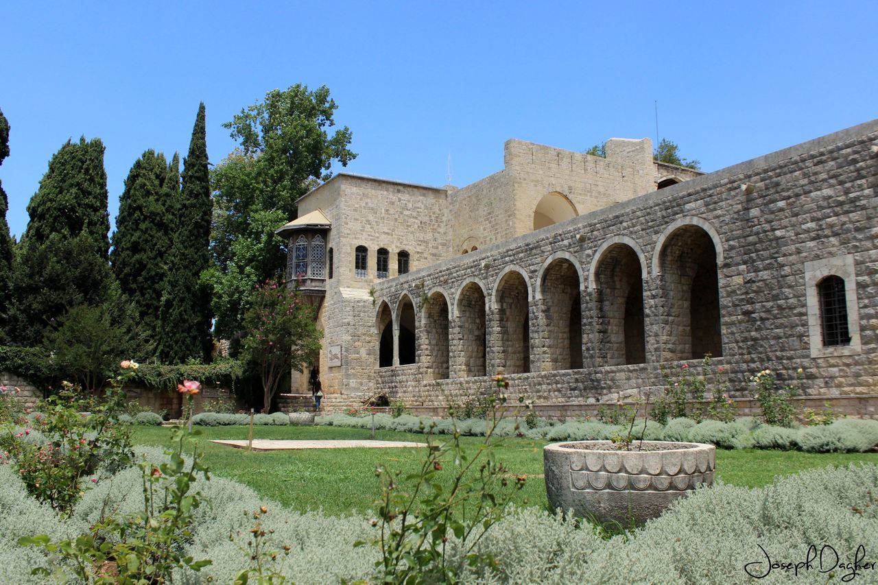 architecture, built structure, building exterior, clear sky, history, old ruin, old, tree, the past, blue, abandoned, ancient, stone wall, low angle view, day, sunlight, house, grass, ruined, arch