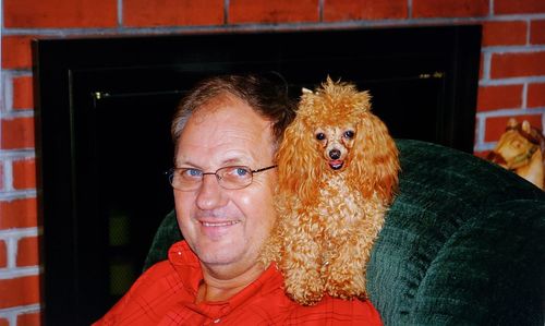 Portrait of smiling man with dog at home