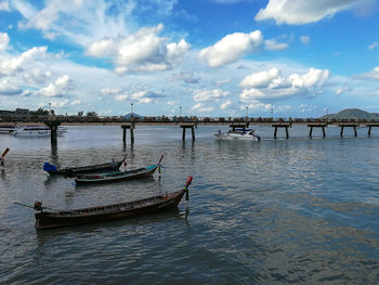 Boats moored in river against sky