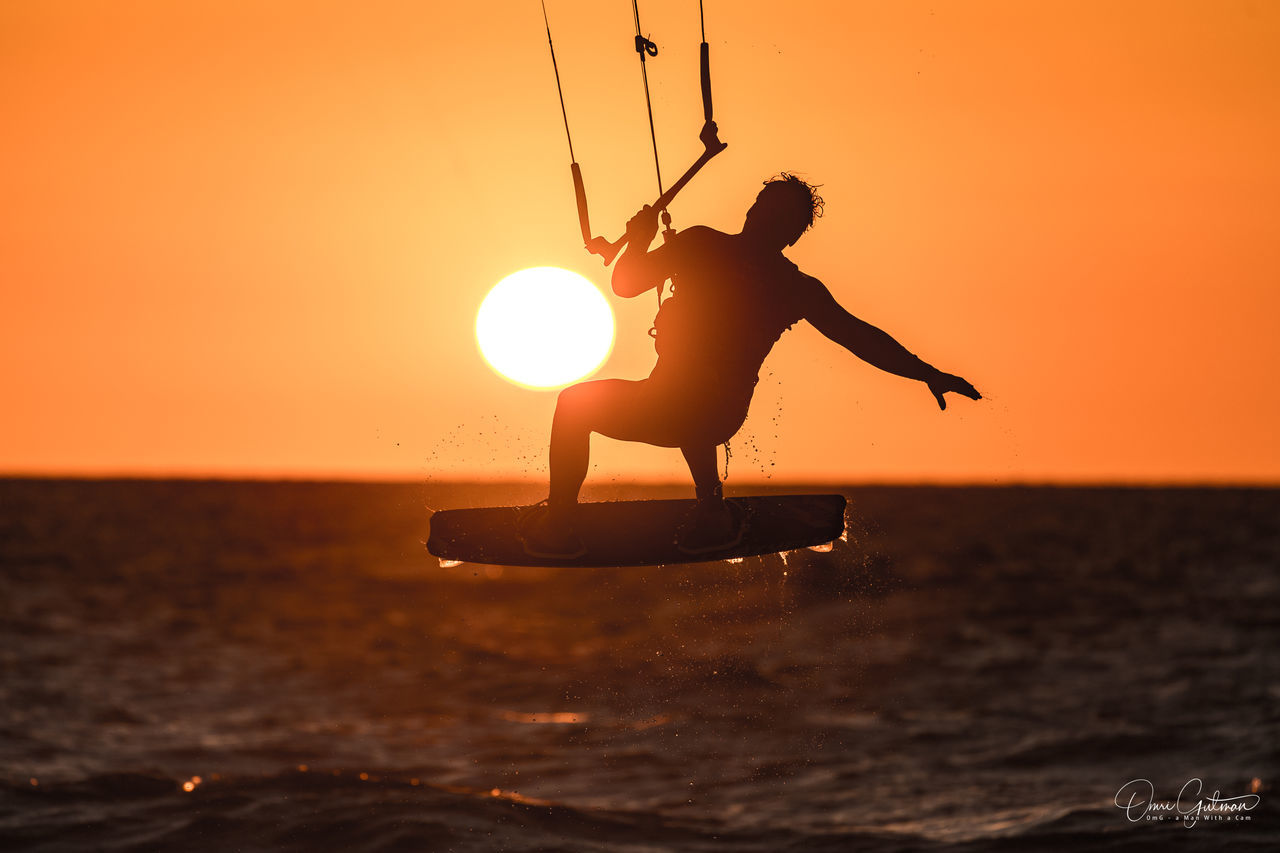 SILHOUETTE MAN IN SEA DURING SUNSET