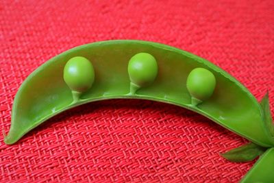 Close-up of green peas on red mat