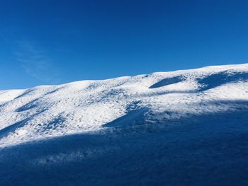 Snowcapped mountains against clear blue sky