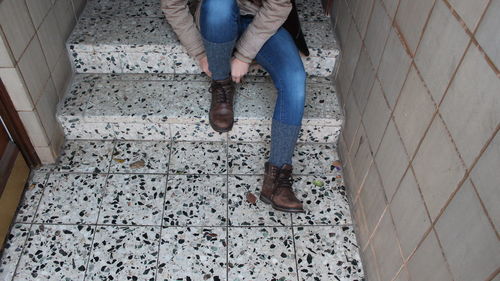 Low section of man wearing shoes while sitting on steps