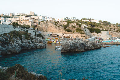 Buildings by sea against clear sky