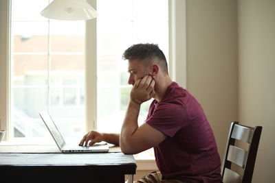 Side view of man working on table