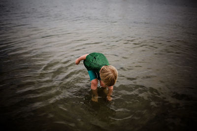 Rear view of man swimming in lake