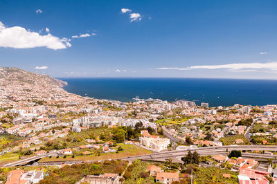 High angle view of townscape by sea against sky