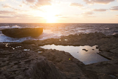 Scenic view of beach against sky during sunset