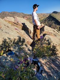 Rear view of woman sitting on rock