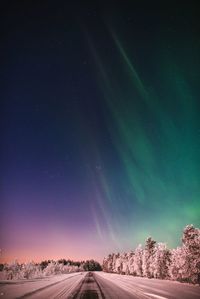 Scenic view of landscape against sky at night during winter