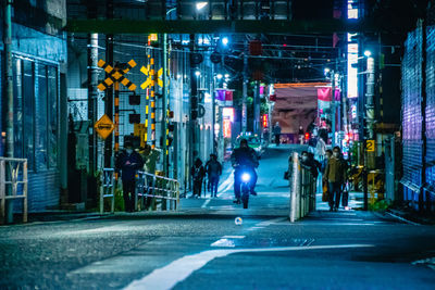 Man walking on illuminated city street at night