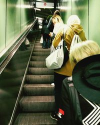 Rear view of woman sitting on subway station