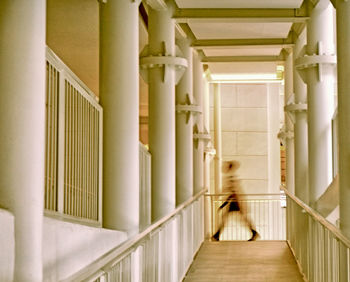 Blurred motion of person walking in corridor of building