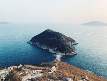 High angle view of rocks by sea against sky