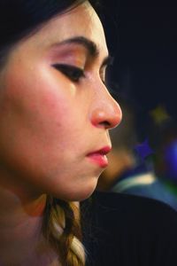 Close-up of woman looking down outdoors at night