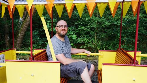 Portrait of smiling bald man sitting in park