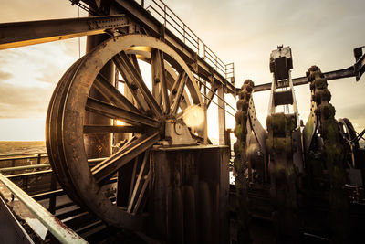 Close-up of old machinery against sky