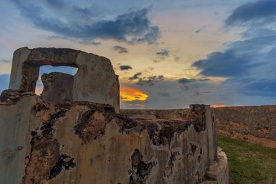 Old rusty metal against sky at sunset