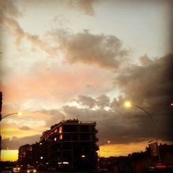 Low angle view of illuminated building against cloudy sky