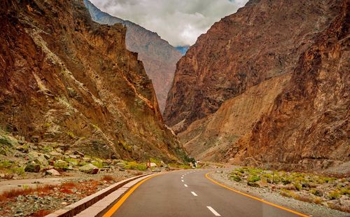 Road amidst rocky mountains against sky