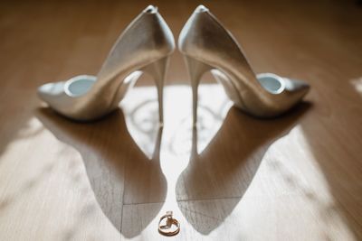 Close-up of high heels and ring on hardwood floor