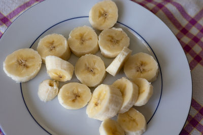 View from above of a white plate with banana slices.