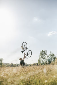 Young man lifting up his bike