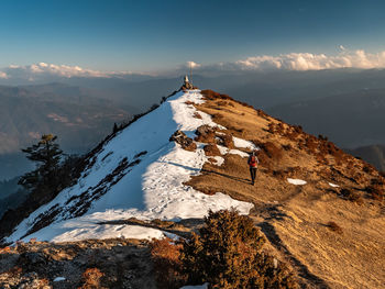 People on snowcapped mountains against sky during winter