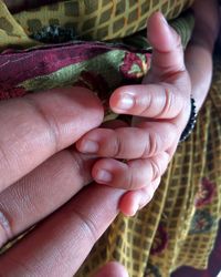 Cropped hands of parent and baby